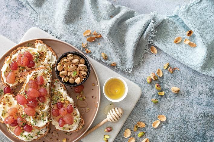 Crostini con caprino, uva rossa e pistacchi