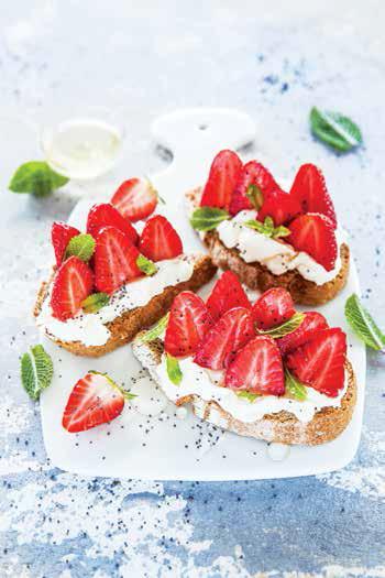 Crostini di pane nero con crema al formaggio, fragole, miele e menta